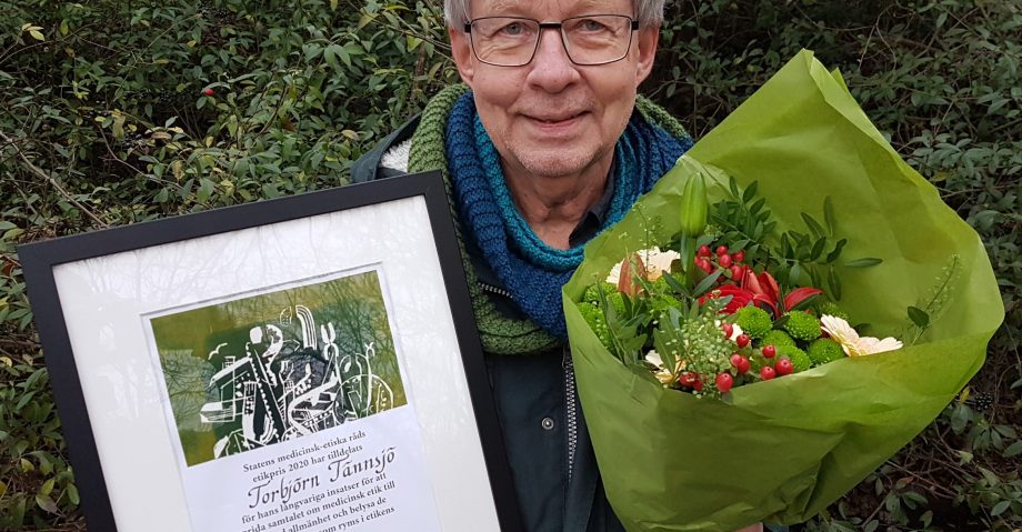 Torbjörn Tännsjö med pristagardiplom och blombukett