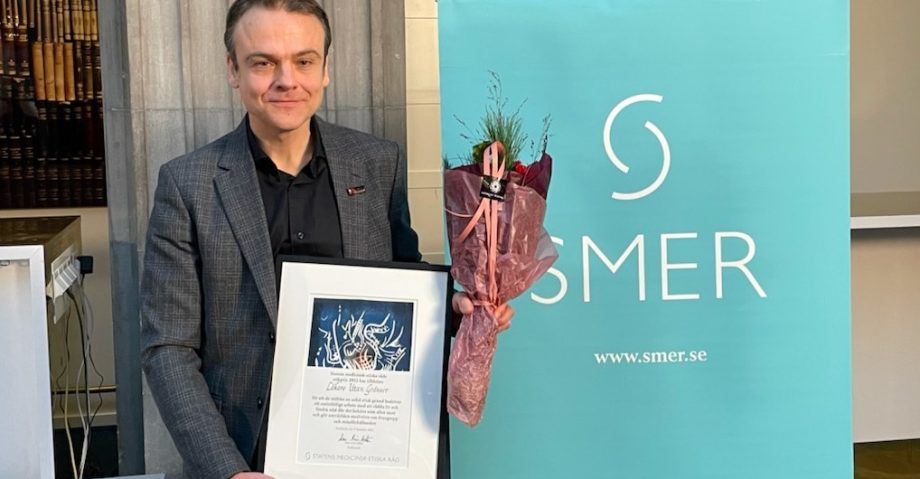 Ordföranden för Läkare utan gränser i Sverige, Peter Moberger, med diplom och blombukett